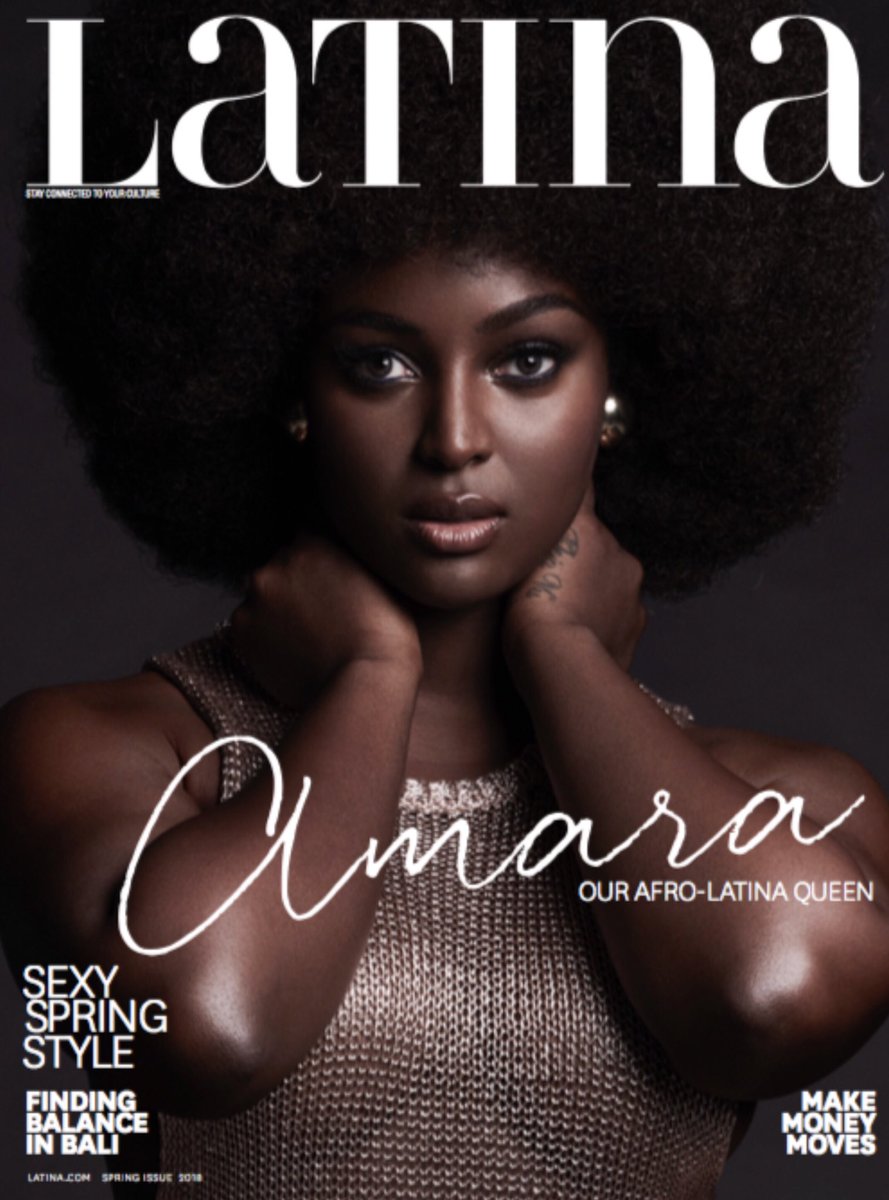 Amara La Negra on the cover of Latina Magazine. She's against a dark grey background and she's wearing a gold woven dress. Her name "Amara" is in cursive across the cover.