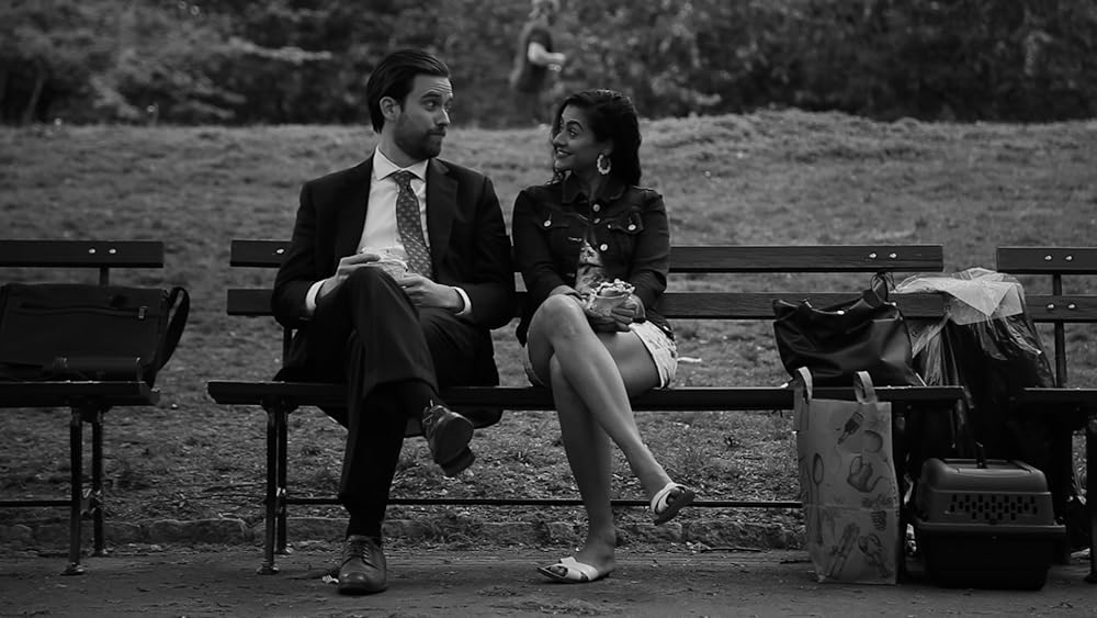 Justin Clark and Kavita Jariwala converse on a park bench.